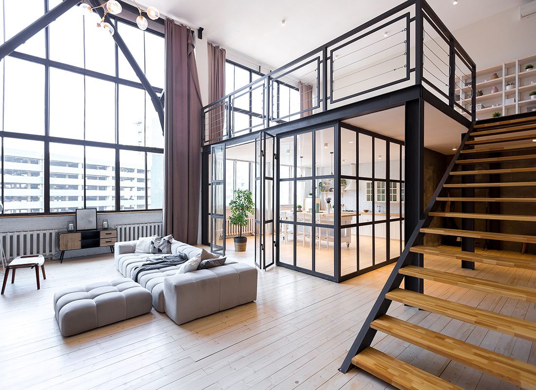 Insurance Solutions - Look Inside a Modern and Bright Loft Style Apartment with Tall Ceilings and Floor Length Windows